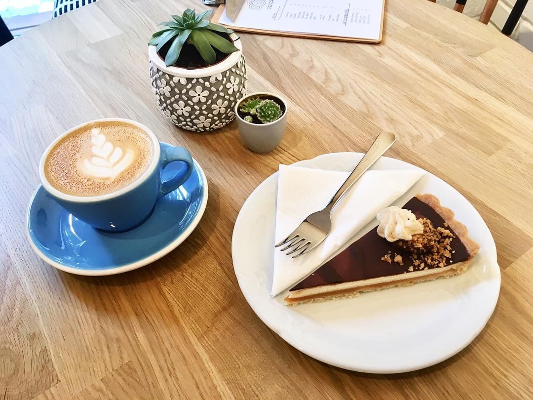 Káva a dortík na stole v Oblak Coffee