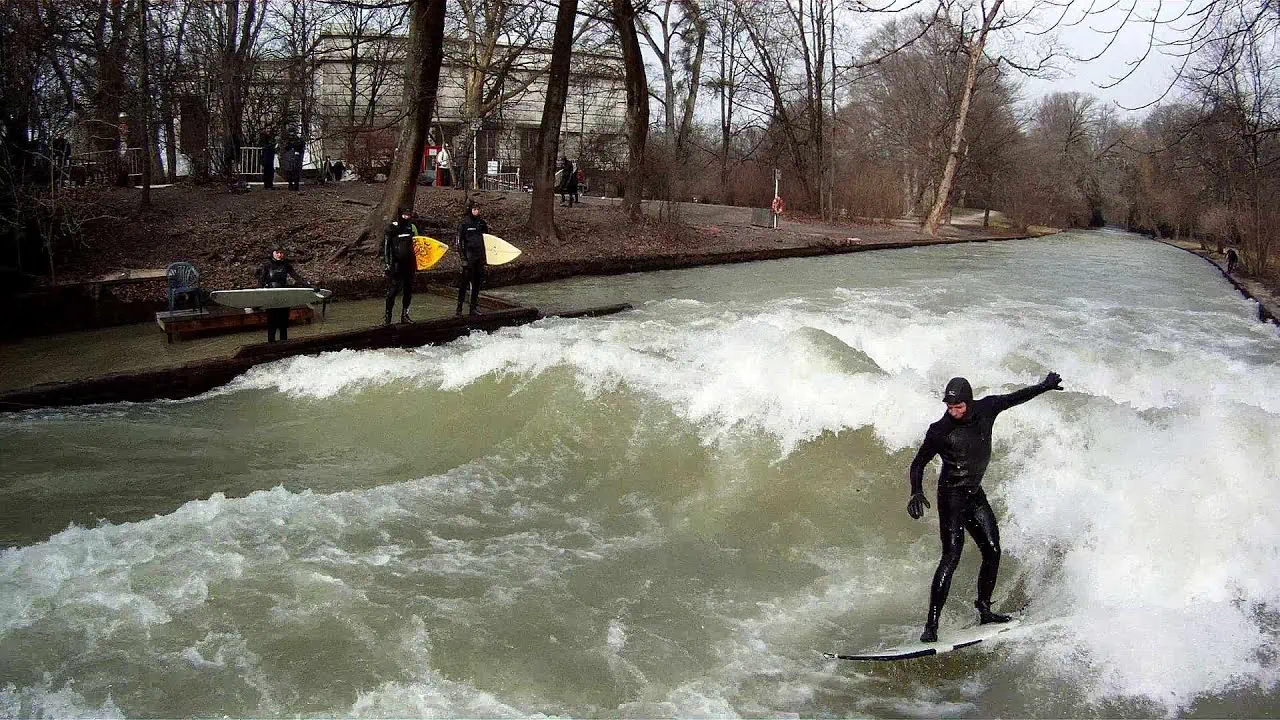 Surfaři na říční vlně Eisbach v Anglické zahradě