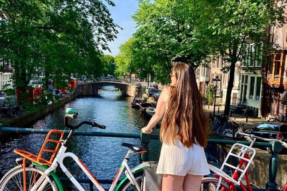 Kurztrips Europa: 21 der schönsten Städte für ein Wochenende 2026 12 Fahrräder auf einer Brücke über eine Amsterdamer Gracht