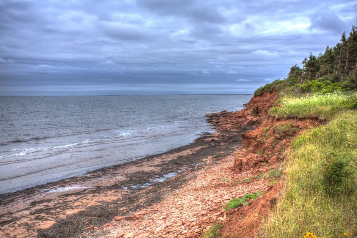 Červené útesy a pláž na severním pobřeží Prince Edward Island