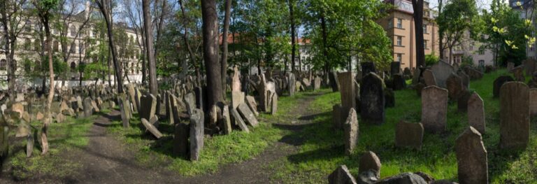 Panorama Starého židovského hřbitova v pražském Josefově s nahuštěnými náhrobky pod stromy