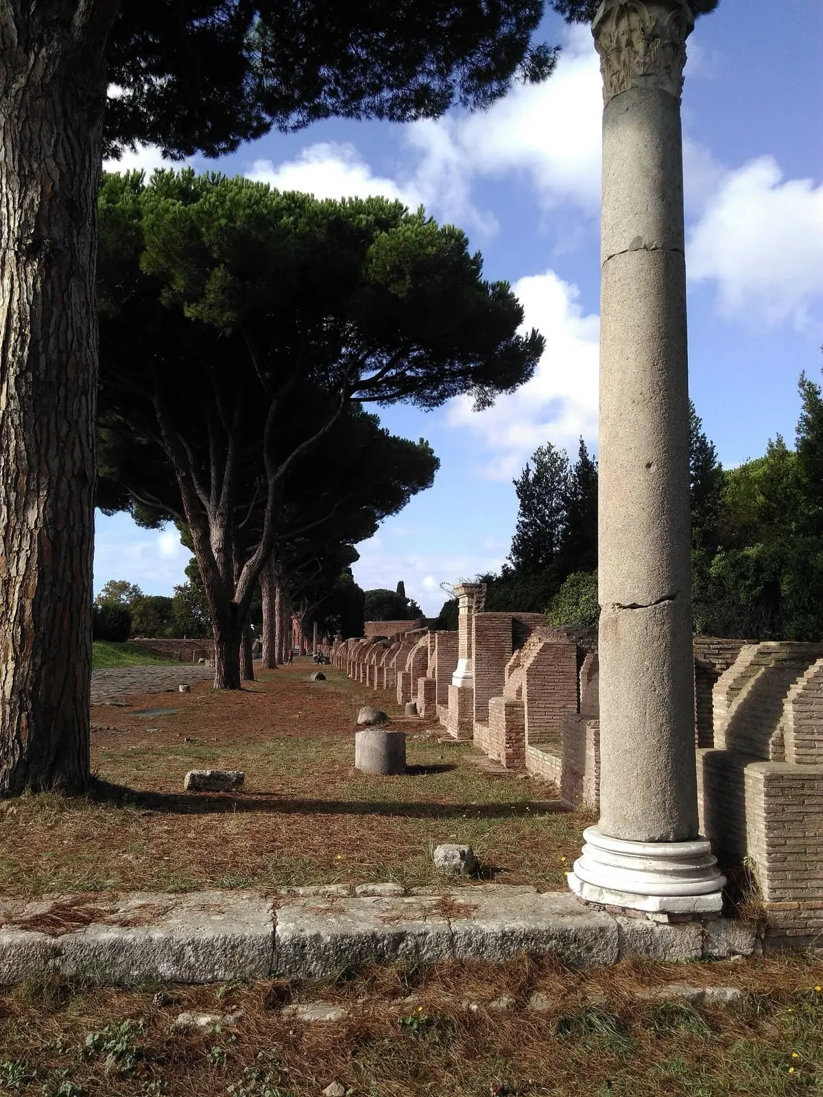 Dláždená hlavná trieda Decumanus Maximus lemovaná ruinami v Ostia Antica