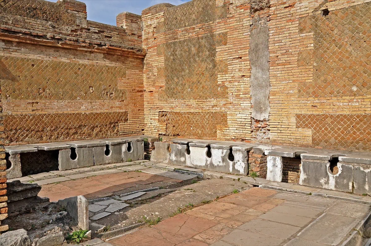 Verejné latríny forica s kamennými sedadlami v Ostia Antica