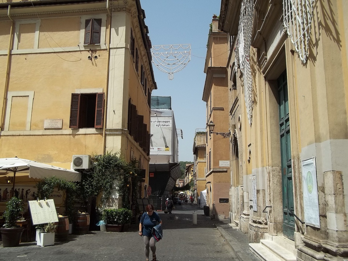 Slunná dlážděná ulička s okrovými domy v Trastevere