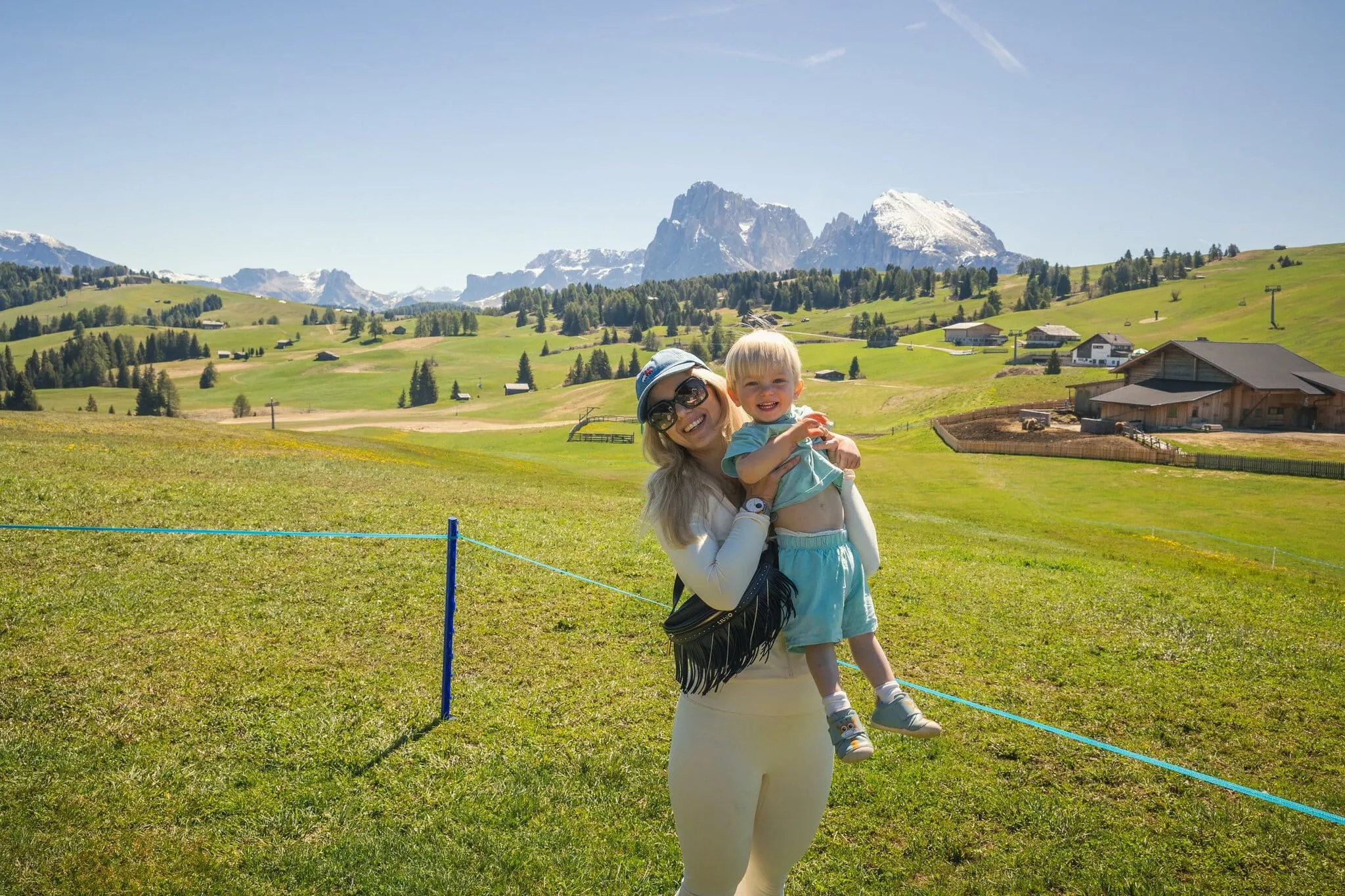 Maminka s dvouletým synem na alpské pastvině s horami
