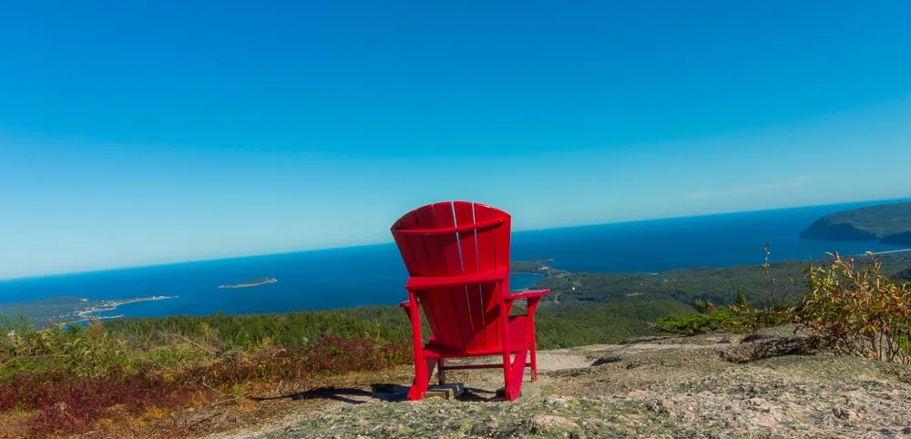 Červená křesla Parks Canada s výhledem na oceán