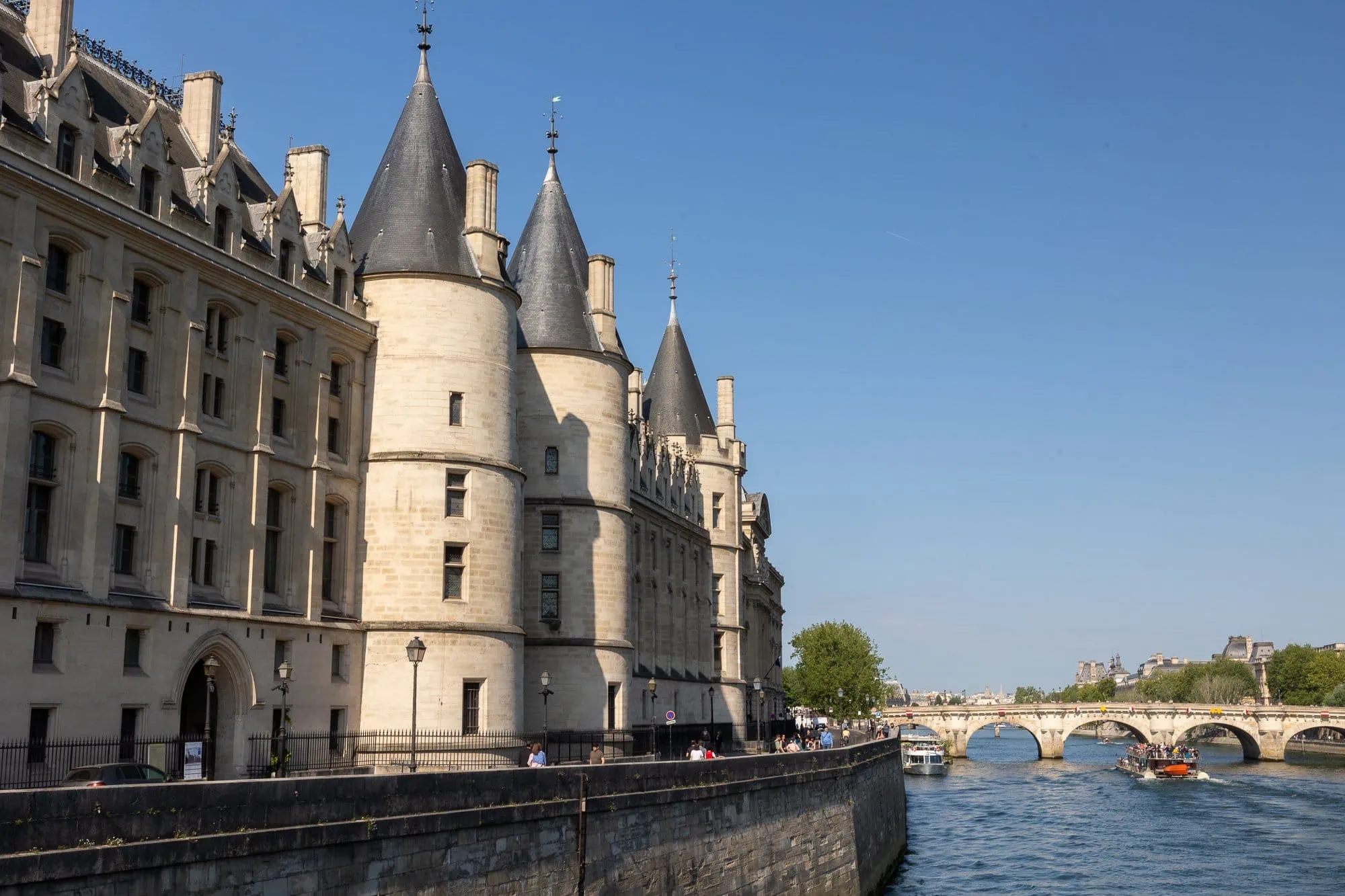 Conciergerie s charakteristickými věžemi nad řekou Seinou v Paříži