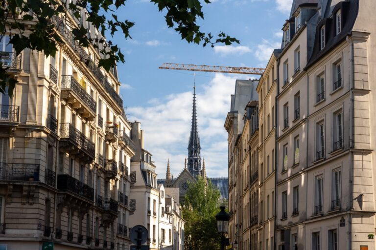 Pařížská ulička s věží Notre-Dame v pozadí