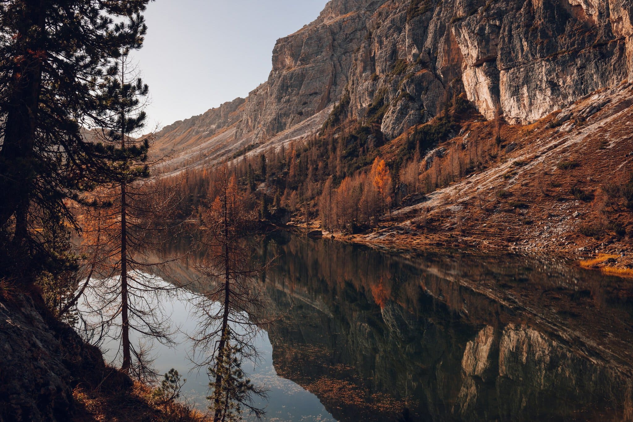 Tyrkysové jezero Lago Federa s oranžovými modříny na podzim