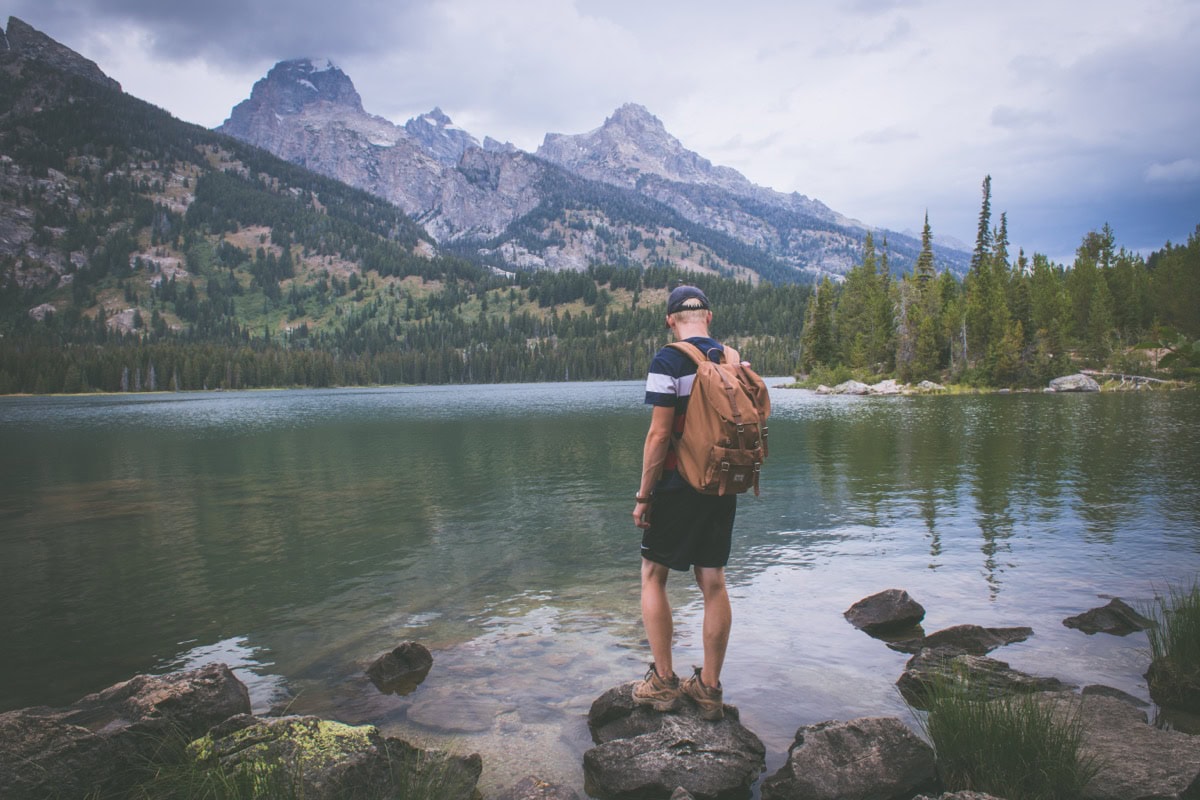 Grand Teton National Park, Wyoming (SUA): Ghid și 15 lucruri de văzut și făcut 1 Turist pe malul lacului cu vedere spre masivul Teton