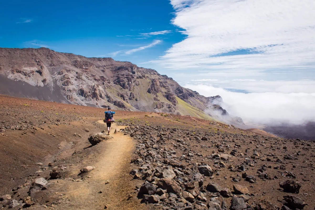 Turista sestupuje stezkou Sliding Sands do krateru Haleakaly