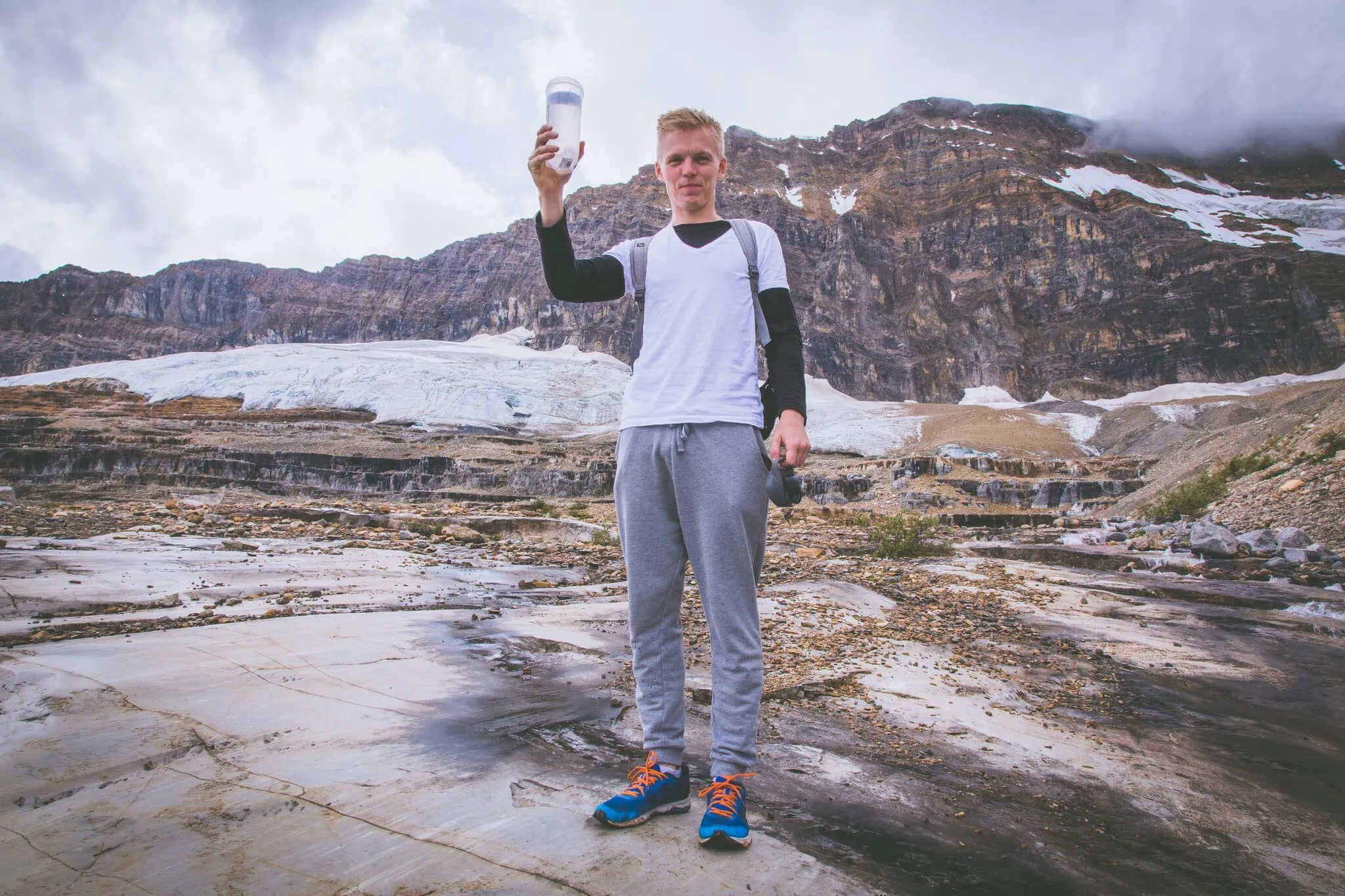 Lukáš holding a thermos in front of the Athabasca Glacier at the Columbia Icefield
