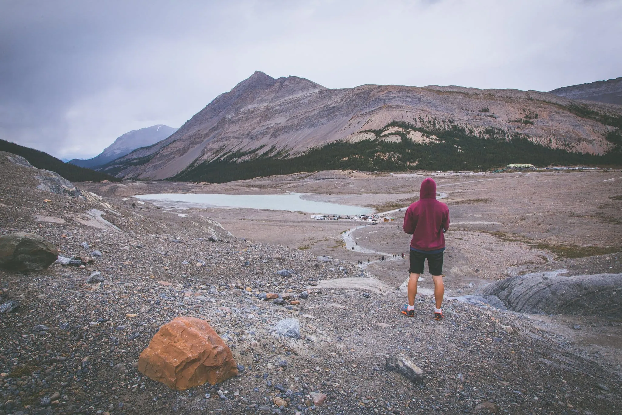 Lukáš standing with his back to the camera at the Athabasca Glacier lake in the Columbia Icefield