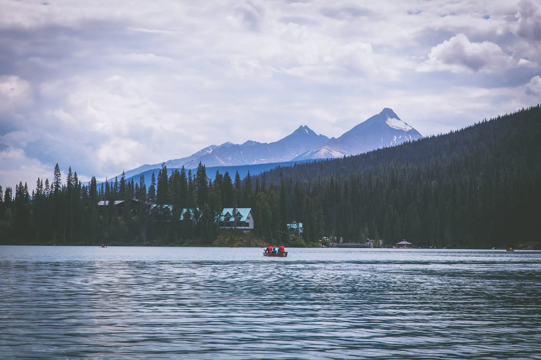 Boat on the calm surface of Maligne Lake with iconic peaks in the background