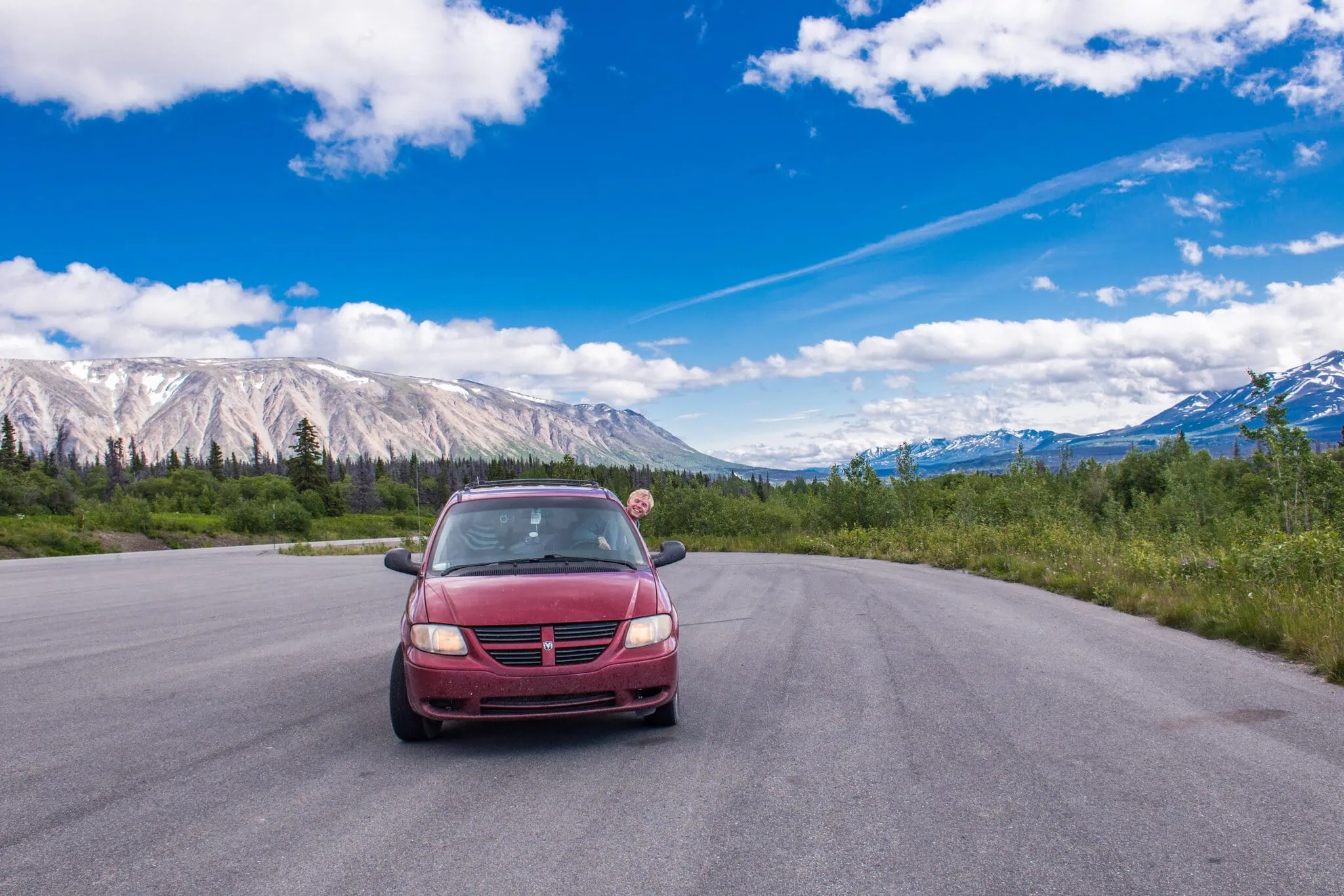 Furgoneta camper roja Chiquita en una carretera de montaña en Alaska