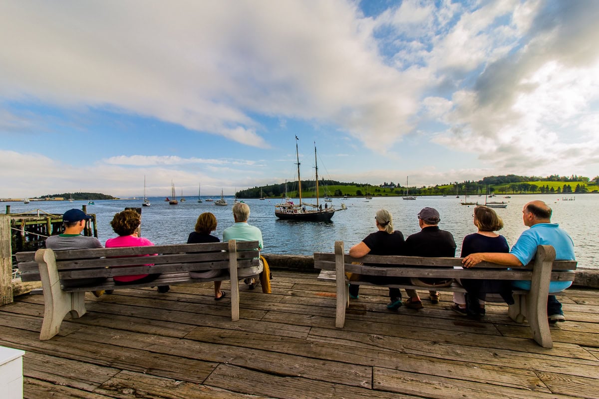 Lunenburg, Nova Scotia: 15 lucruri de văzut și făcut în cel mai colorat orășel din Canada 1 Oameni pe bănci privind velierele în portul Lunenburg