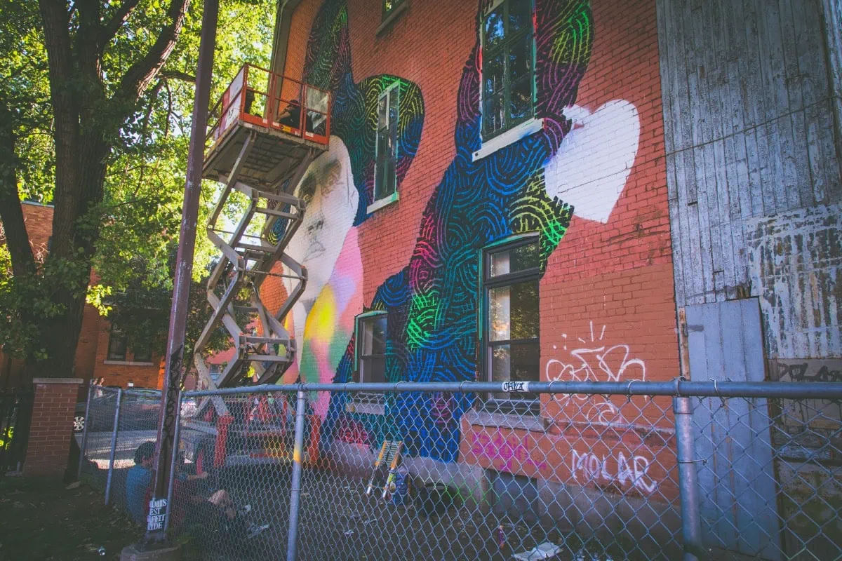 Velky barevny streetartovy mural na cihlove zdi v Montrealu