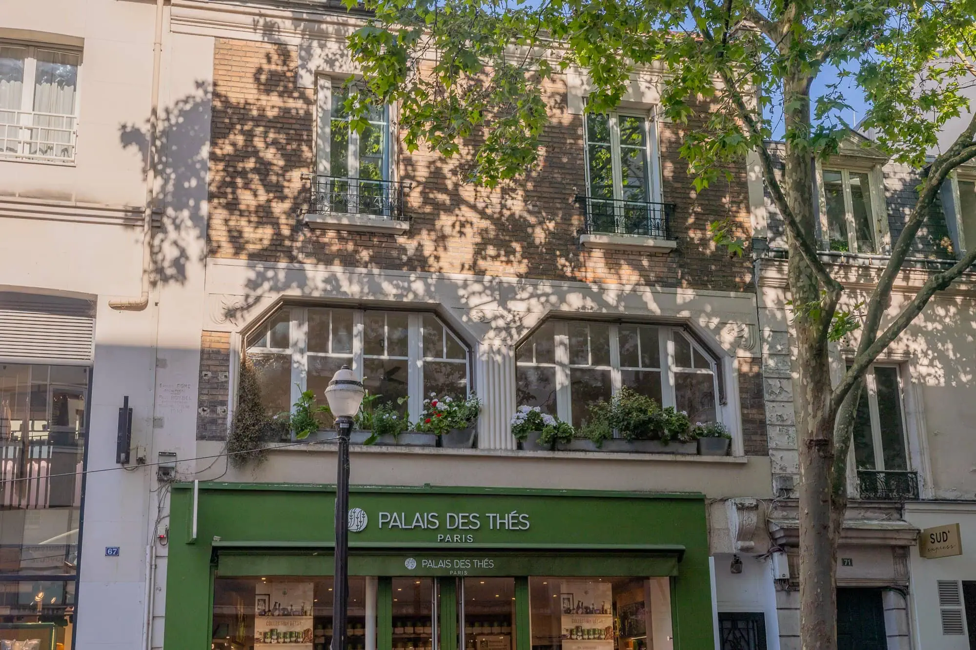 Zelený obchod Palais des Thés v parížské ulici s květinami