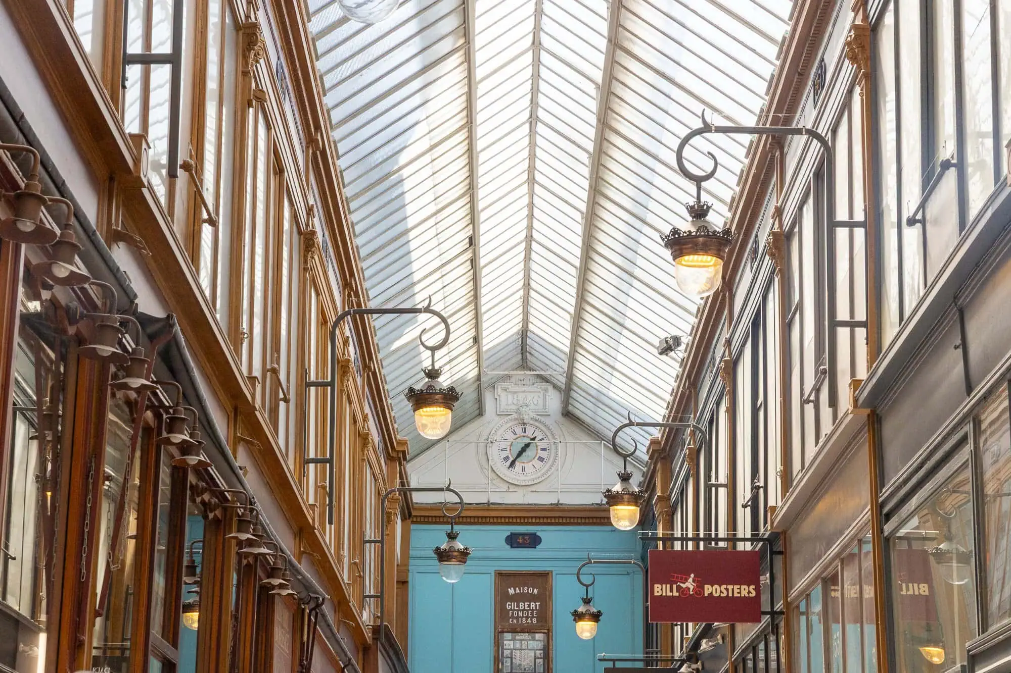Nádherná krytá parížská pasáž se skleněnou střechou, elegantními lampy a historickými obchody