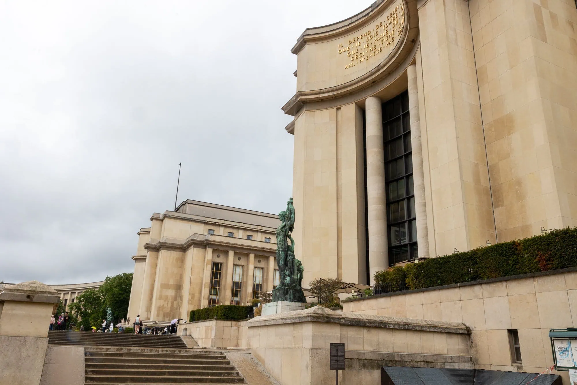 Budova parížskeho múzea s bronzovou sochou pred fasádou