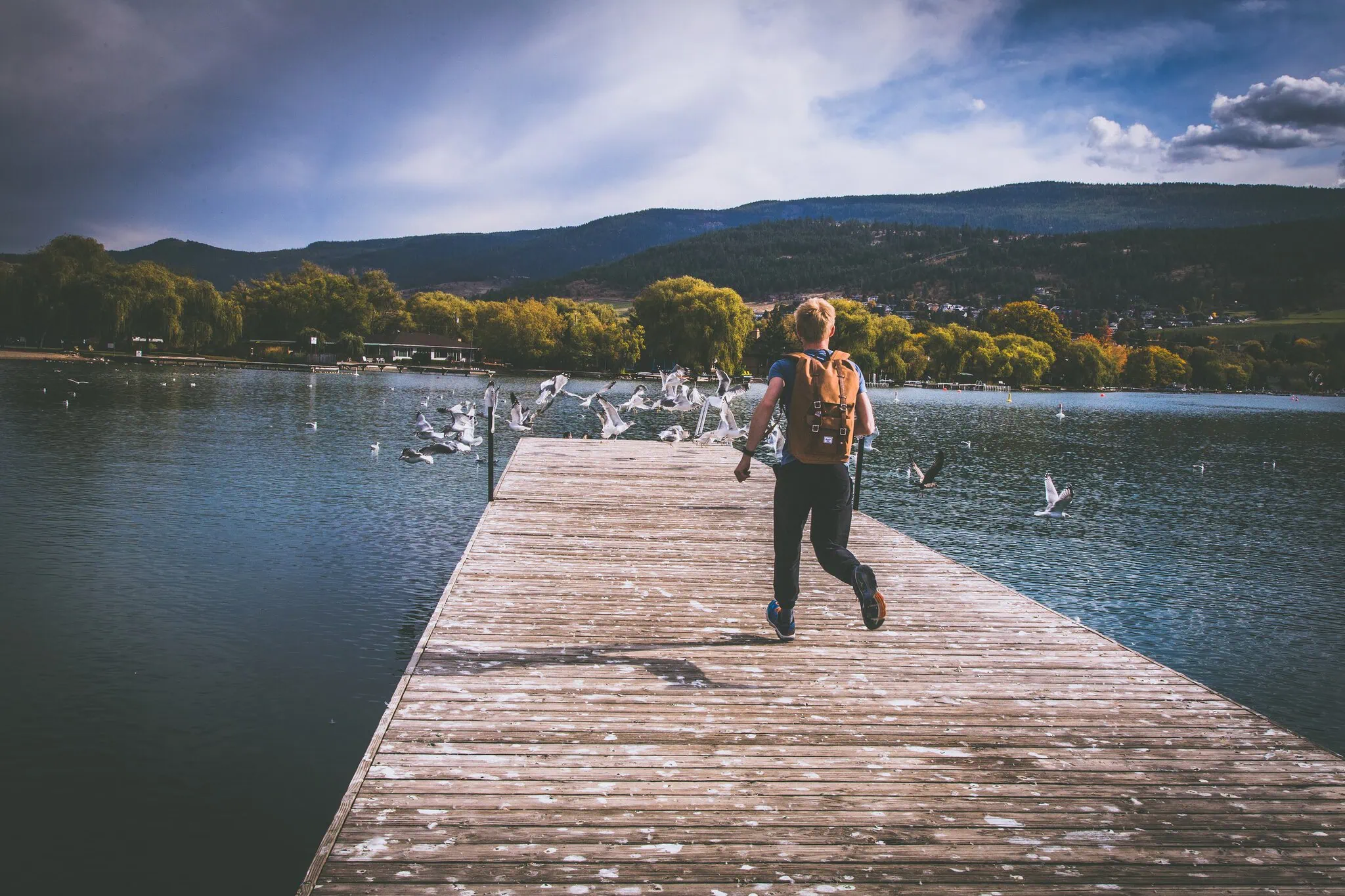 Lukáš běží po molu nad Okanagan Lake a plaší racky