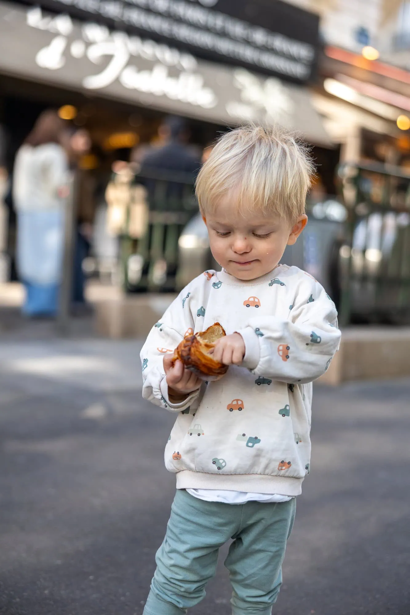 Batole jí čerstvý croissant z pařížské pekárny