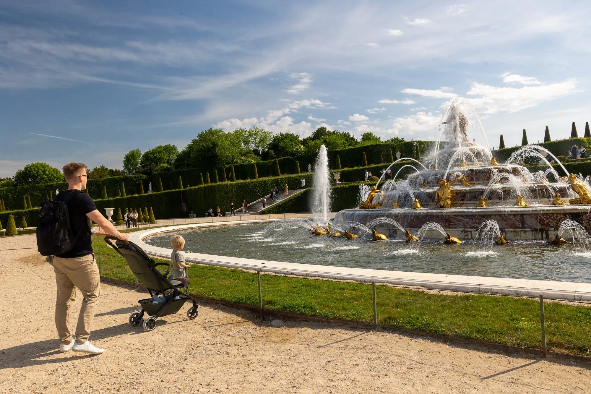 Paříž s dětmi: Kompletní průvodce rodinnou Paříží (na co se připravit s kočárkem) 9 Otec s dítětem u krásné fontány v zahradě Versailles