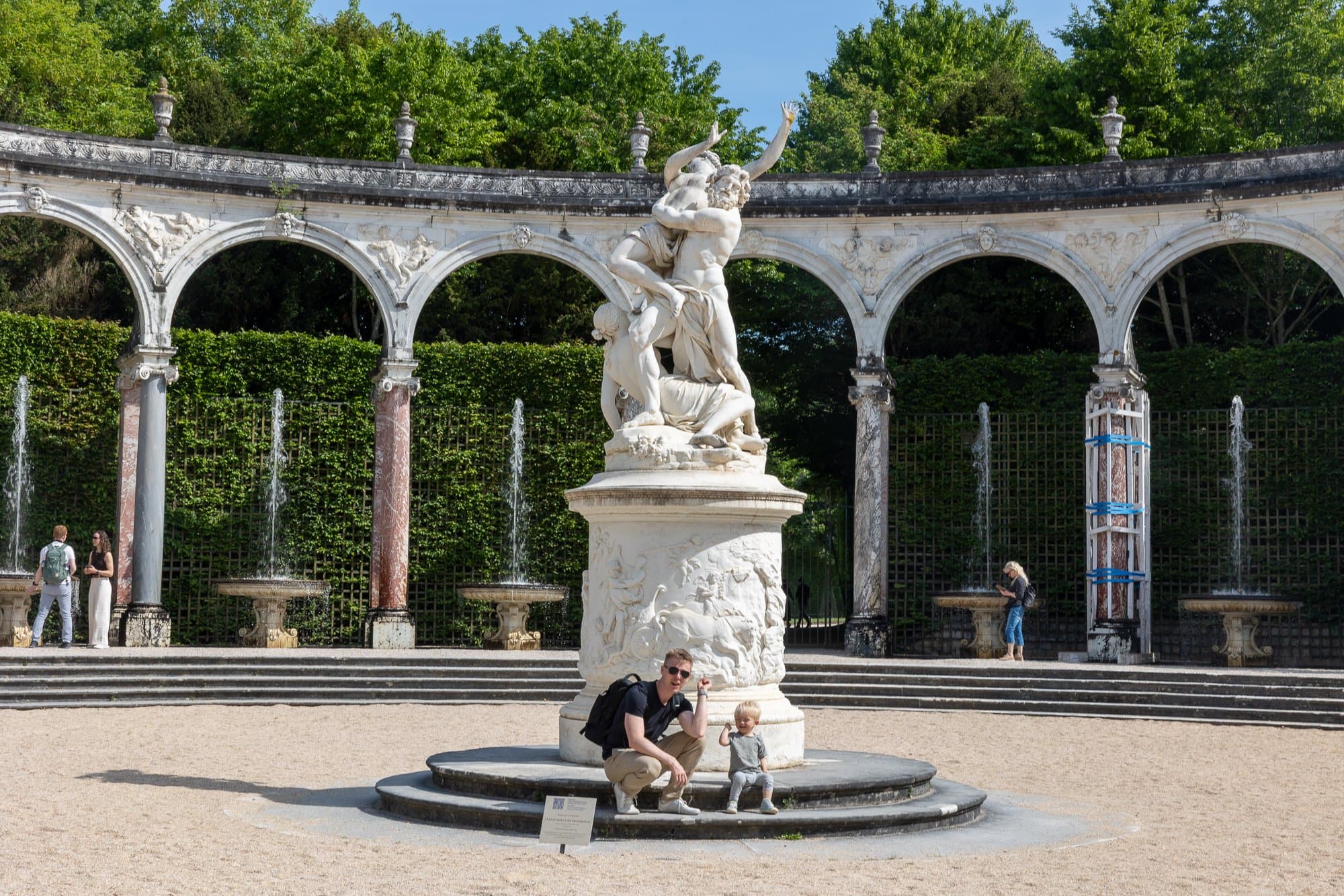 Paris cu copii: Ghidul complet pentru un city break în familie (la ce să te aștepți cu căruciorul) 12 Statuie figurativă din marmură pe un piedestal într-o grădină clasică cu arcadă