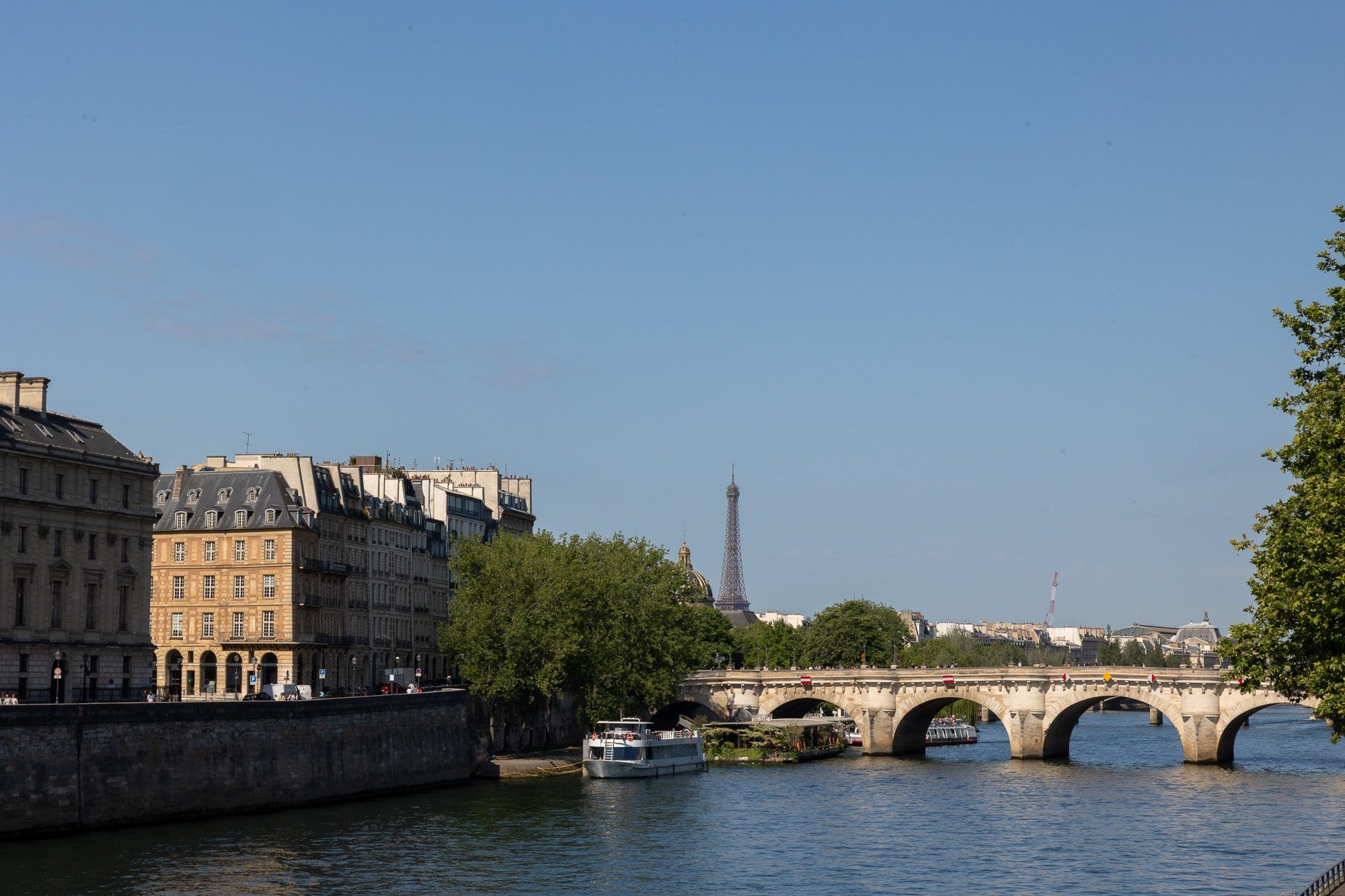 Paris în 3 zile: Itinerariul perfect (+ variante de 2 și 5 zile) 4 Turnul Eiffel vizibil în spatele unui pod de piatră peste râul Sena în Paris