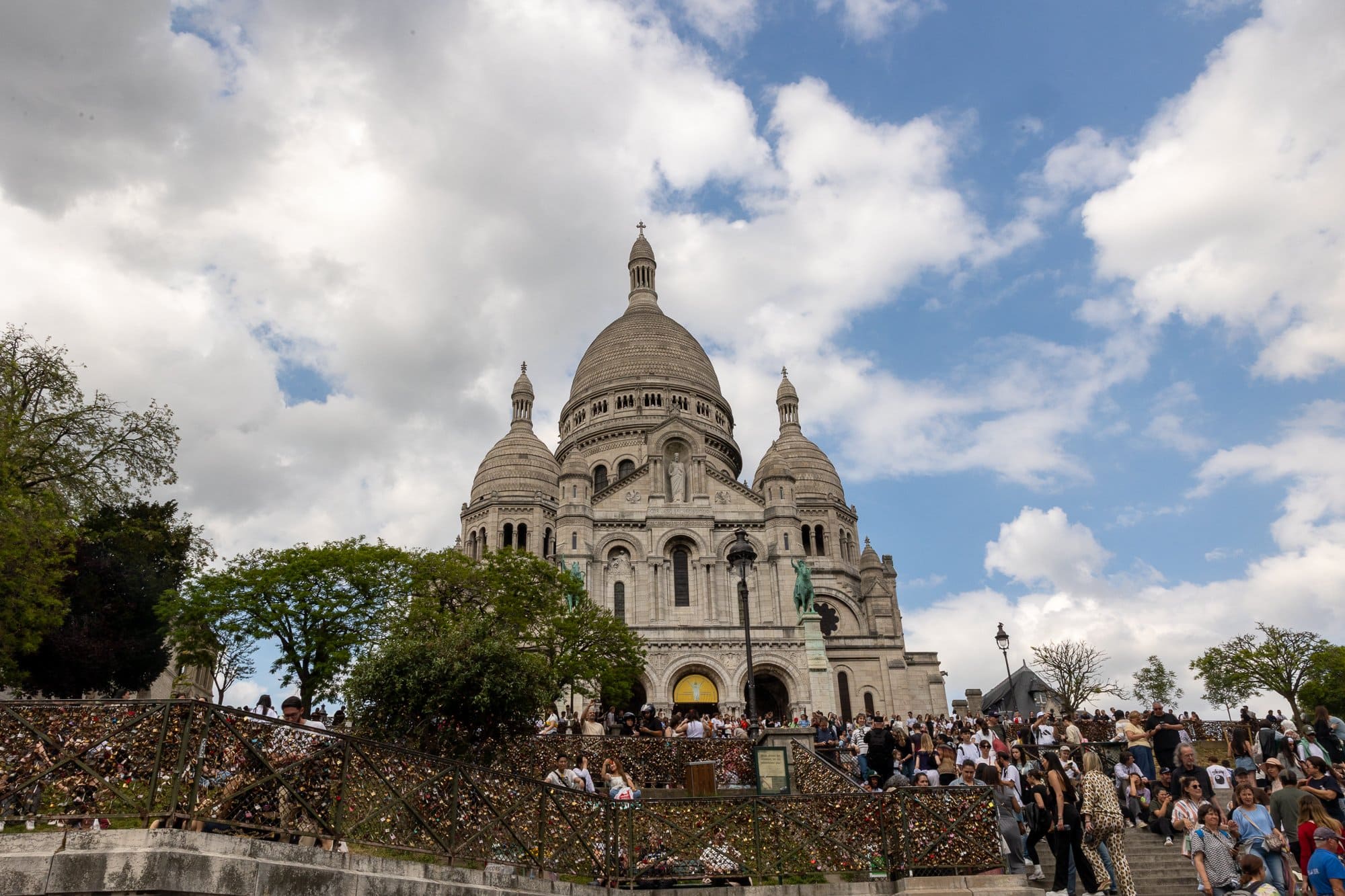 Myter och legender om Paris: Från Paris-syndromet till Fantomen på operan 9 Den vita basilikan Sacré-Cœur på Montmartre med turistskaror och blå himmel
