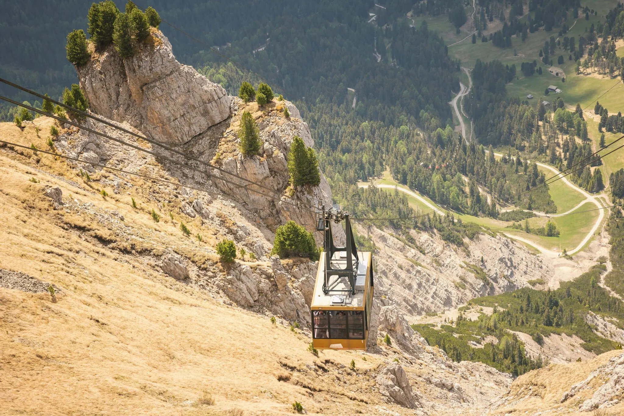 Seceda, Dolomity: 10 tipů, co vidět a dělat 4 Lanovka na Secedu sjíždí po strmé skalní stěně do údolí