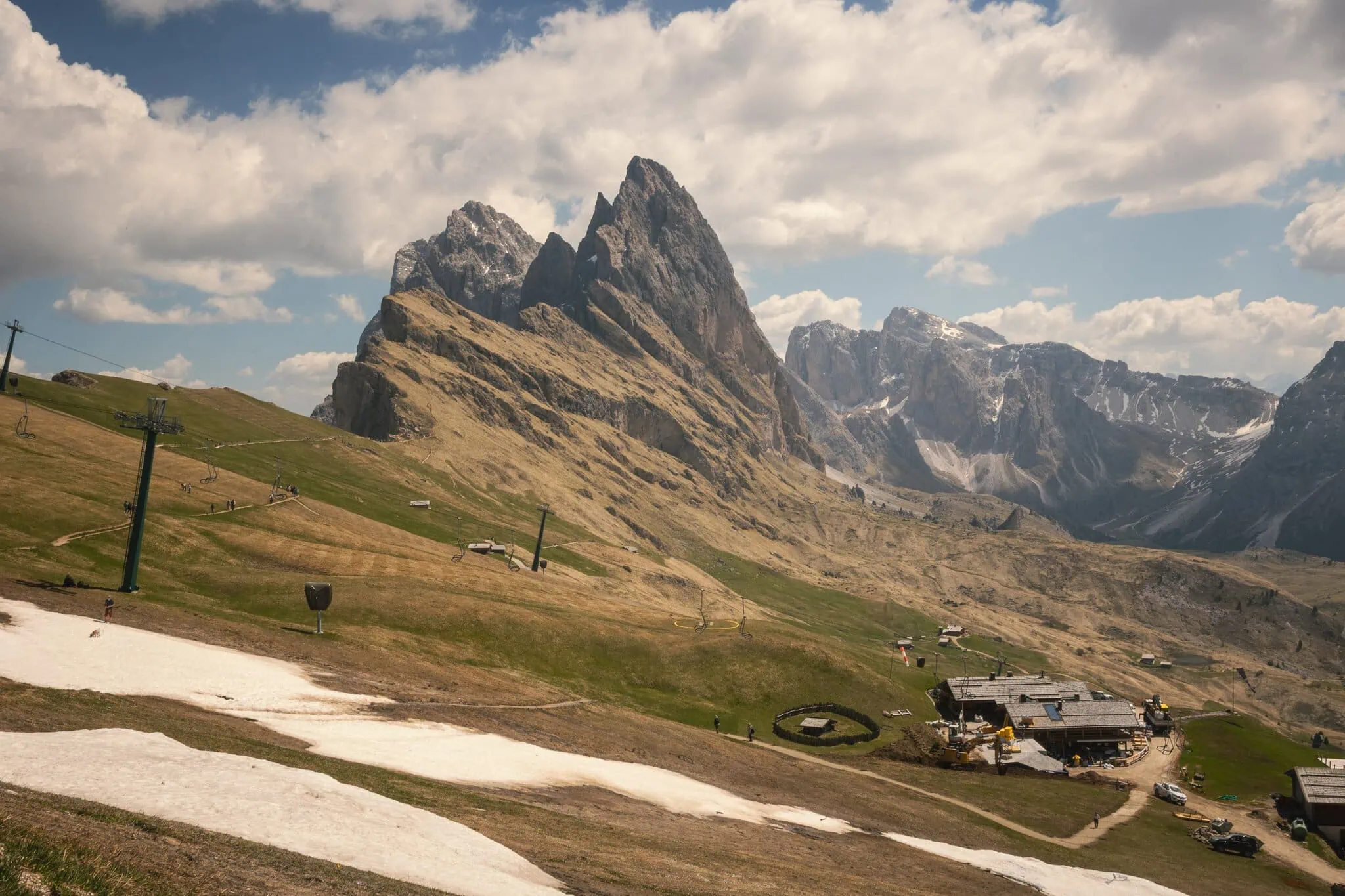 Seceda, Dolomity: 10 tipů, co vidět a dělat 3 Masiv Sassolungo s pastvinami a zbytky sněhu koncem jara