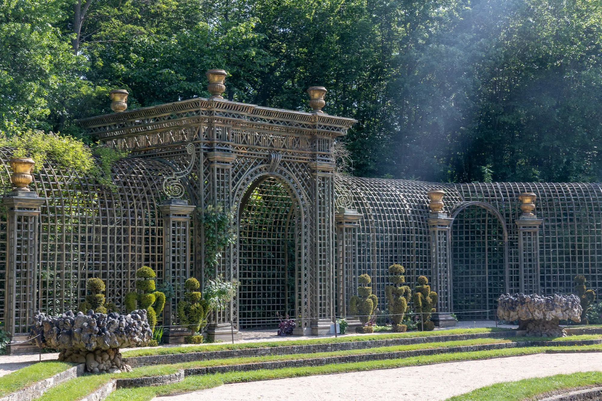 Neoklasická záhradná pergola s ornamentálnou mrežovinou a bronzovými vázami