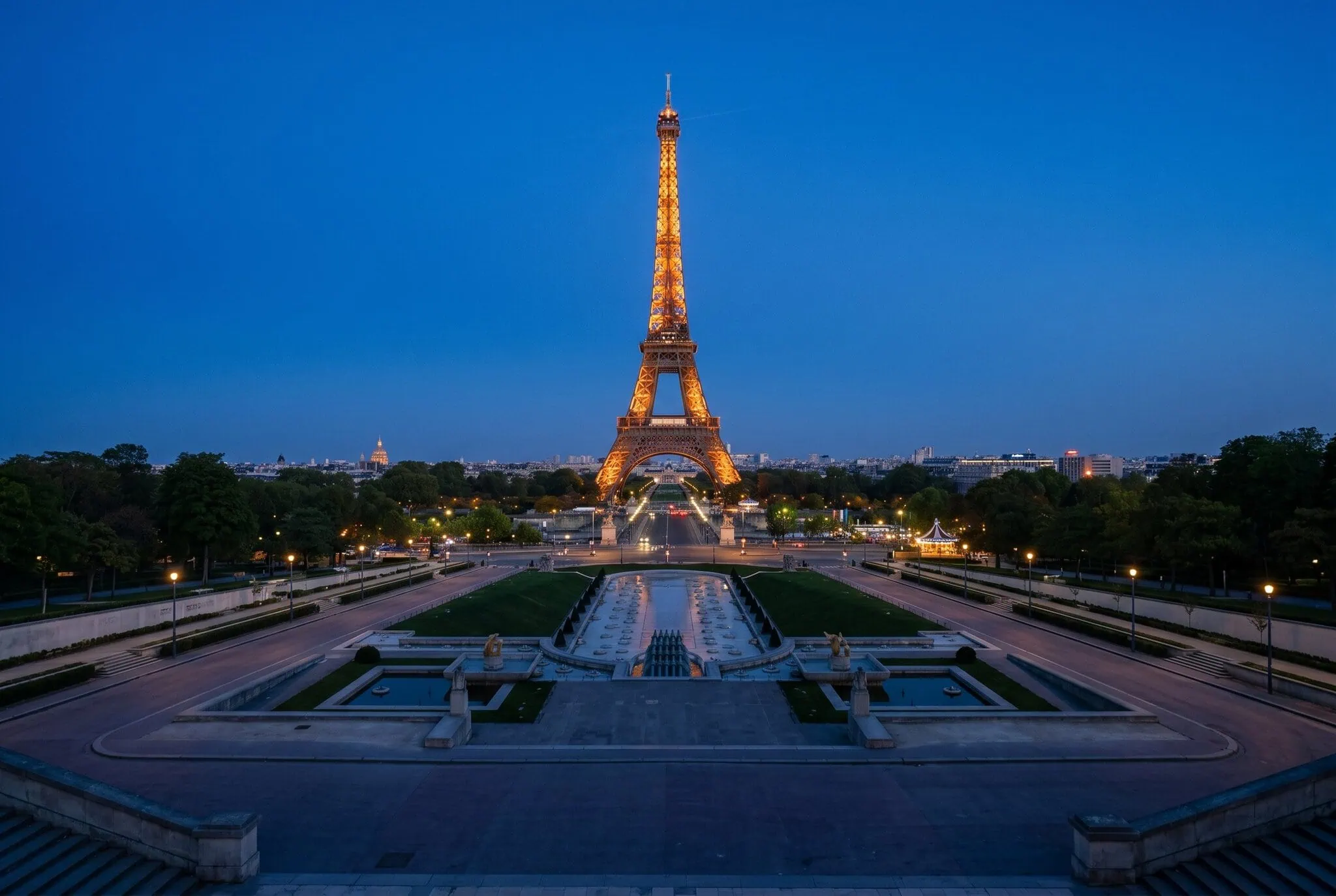 Torre Eiffel illuminata color ambra nell'ora blu vista dal Trocadéro