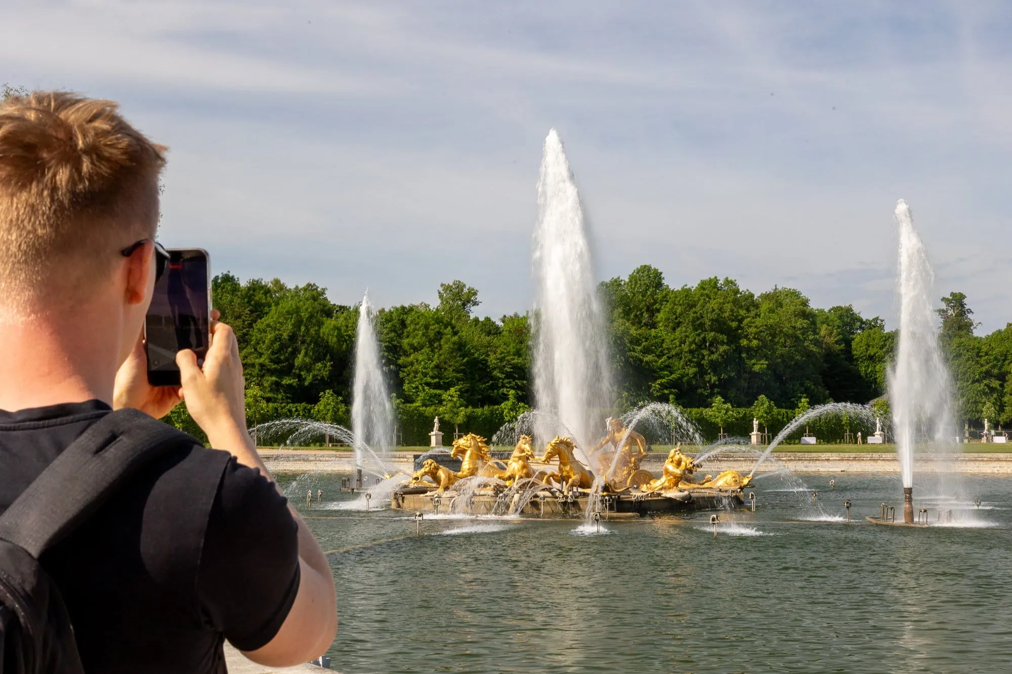 Chlapec fotí zlaté fontány s vodními střikami v Versailles