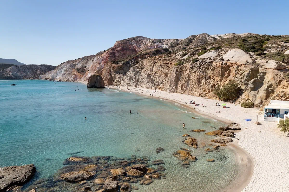Firiplaka beach beneath colourful volcanic cliffs, seen from above