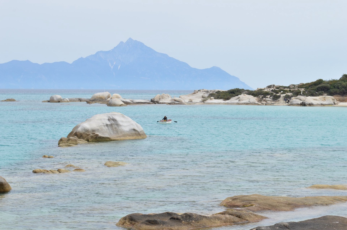 Orange Beach na poloostrově Sithonia s oranžovým pískem, skalkami a výhledem na horu Athos