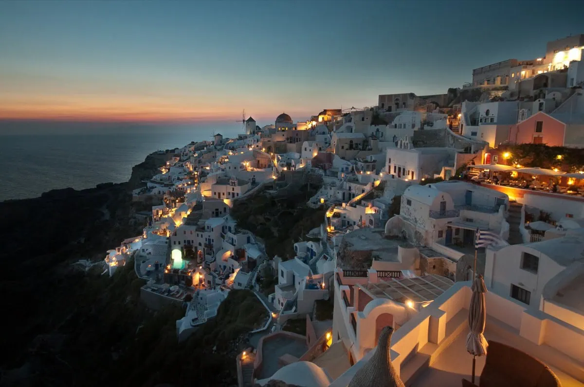 Romantic sunset over the Santorini caldera with a calm sea and warm evening sky