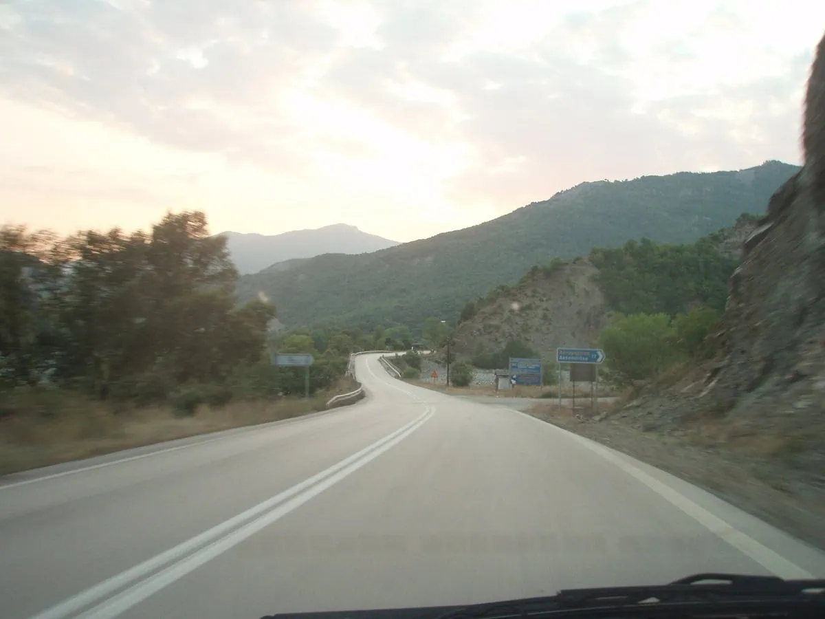 Strada di montagna nel paesaggio greco con catena montuosa sullo sfondo