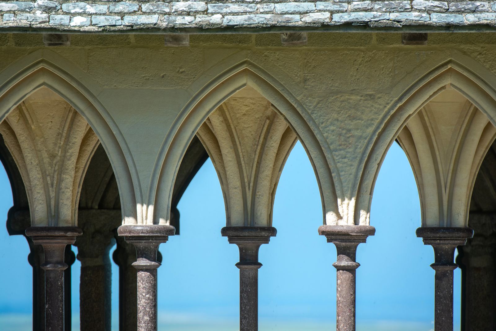 Mont-Saint-Michel, França: 12 dicas + como visitar em 2026 6 Arcos goticos do claustro da abadia de Mont-Saint-Michel