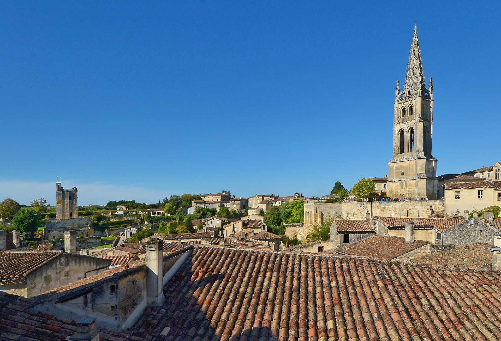 Zvonice monolitického kostela nad střechami Saint-Émilion