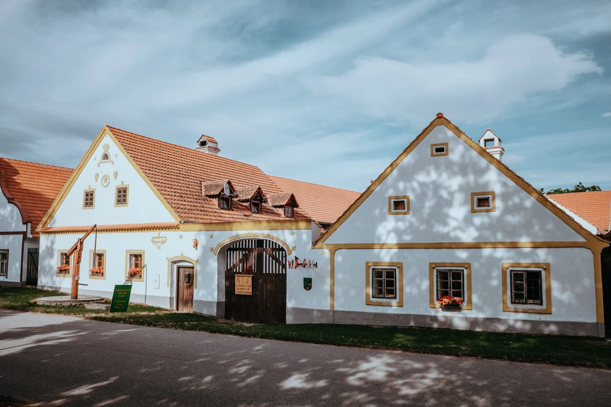 Holašovice in Tschechien: 7 Tipps für das UNESCO-Dorf im Bauernbarock 2026 3 Verzierter weißer Giebel im Bauernbarock-Stil an einem Hof in Holašovice