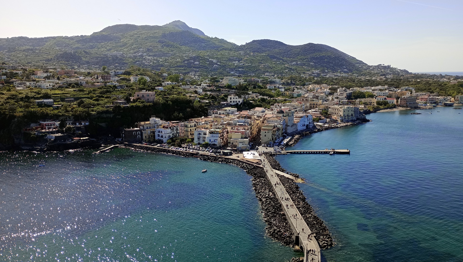 Ischia a Procida: ostrovy v Neapolském zálivu — 8 tipů, co vidět a dělat 1 Ischia Ponte s kamennou cestou ke Castello Aragonese a horou Epomeo v pozadí