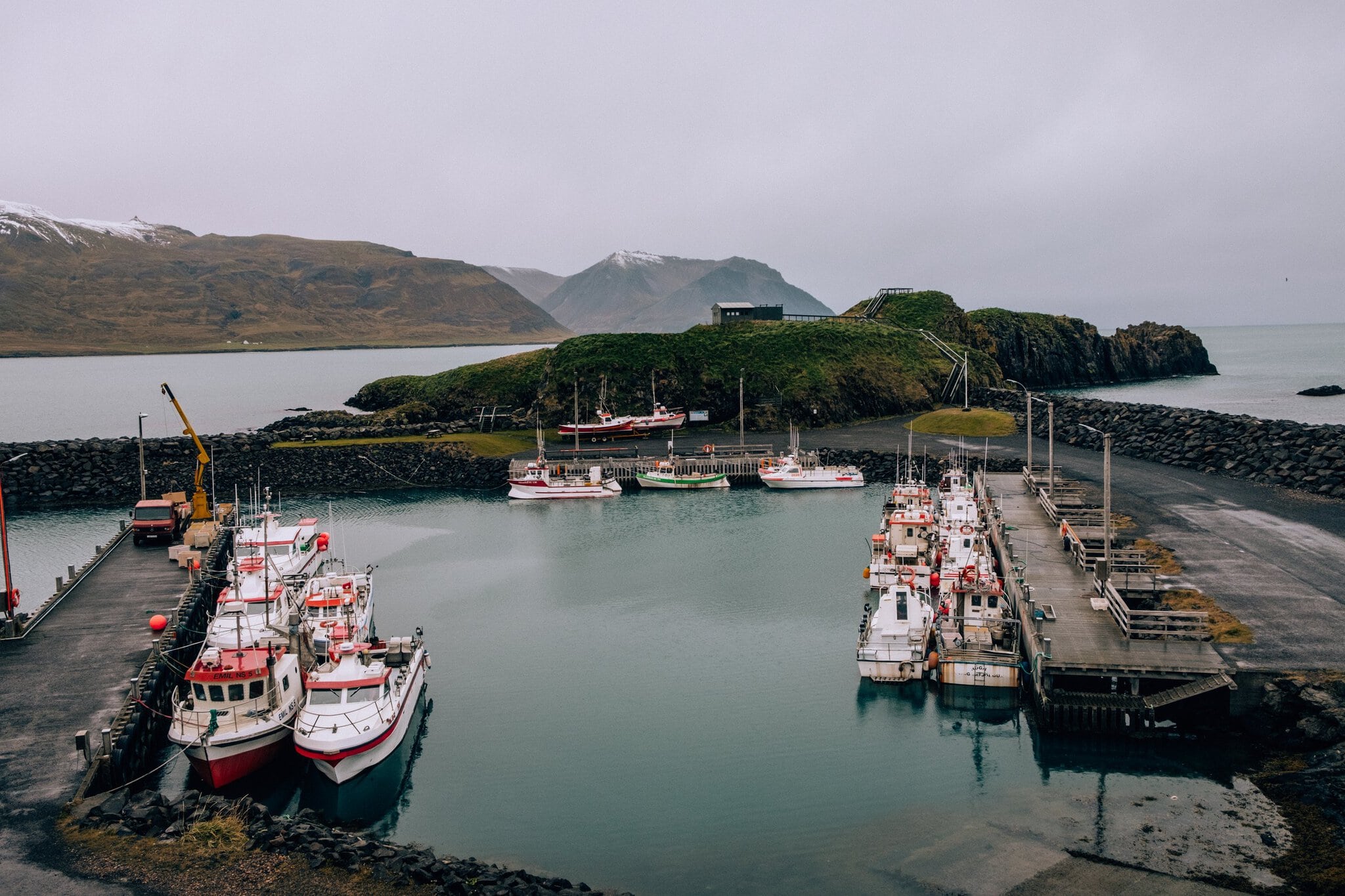Când să mergi în Islanda: vremea lună cu lună 18 Portul Borgarfjörður eystri cu bărci de pescuit și o insulă stâncoasă
