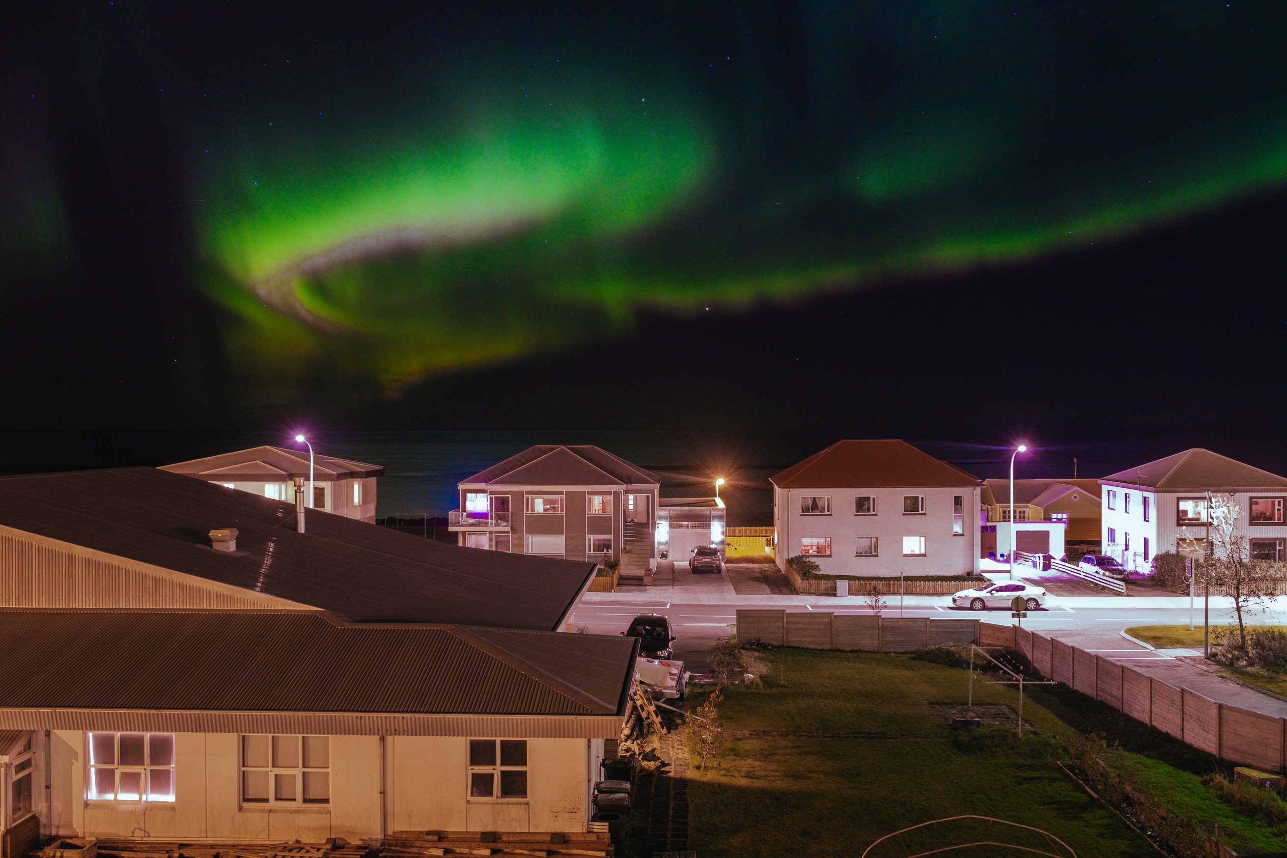 Noorderlicht boven de nachtelijke wijk van Reykjavík