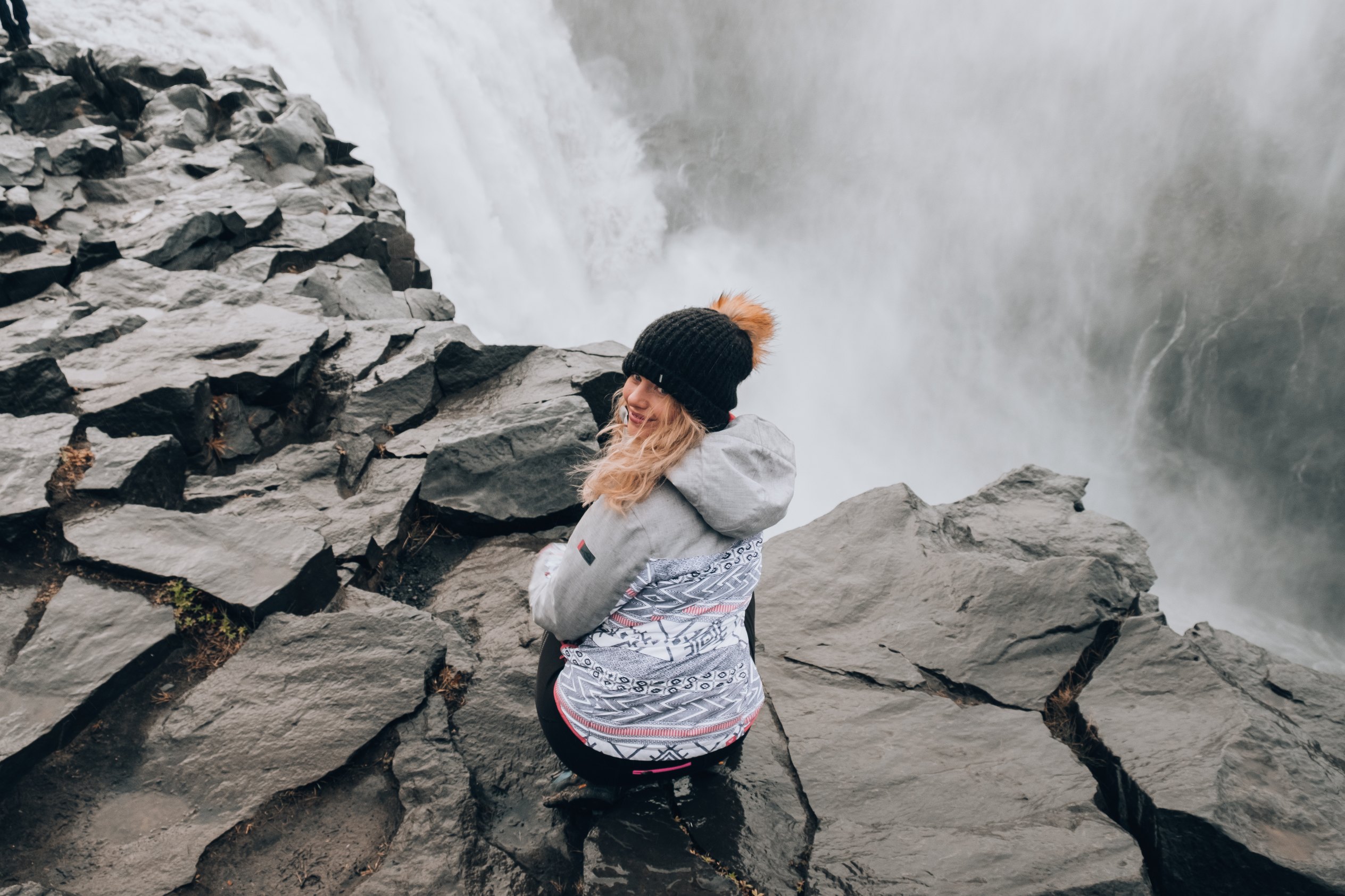 Islande du Nord et Diamond Circle : 12 choses à voir et à faire en 2026 16 une femme près de Dettifoss entourée de brume et de rochers basaltiques