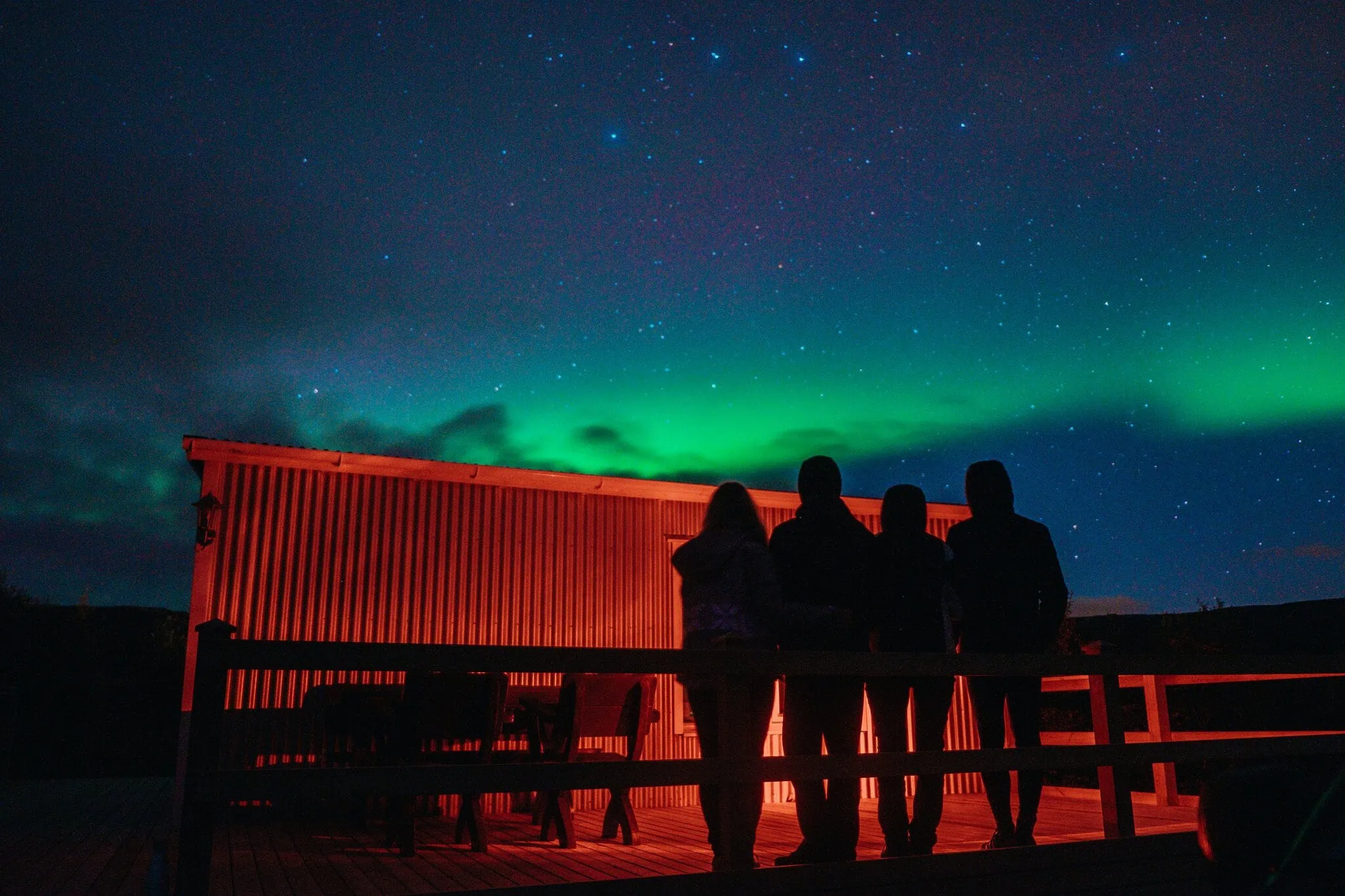 Fiordes Ocidentais (Westfjords), Islândia: 12 dicas do que ver e fazer 9 Silhuetas de pessoas observando a aurora boreal na Islândia à noite