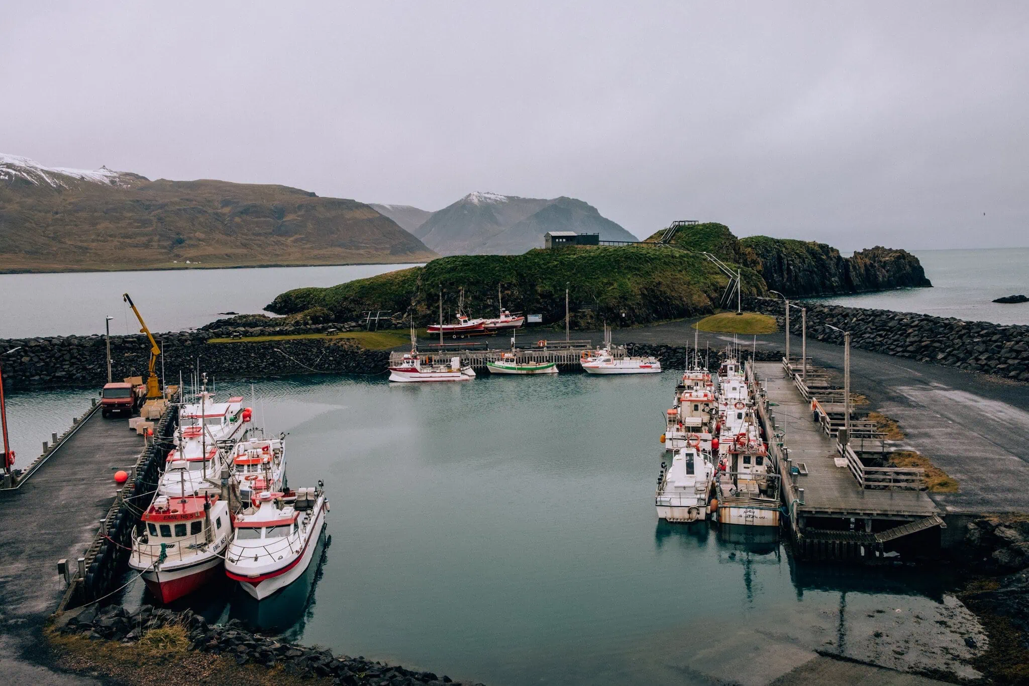 Fiordes Ocidentais (Westfjords), Islândia: 12 dicas do que ver e fazer 4 porto de Borgarfjörður eystri com barcos de pesca e uma ilha rochosa