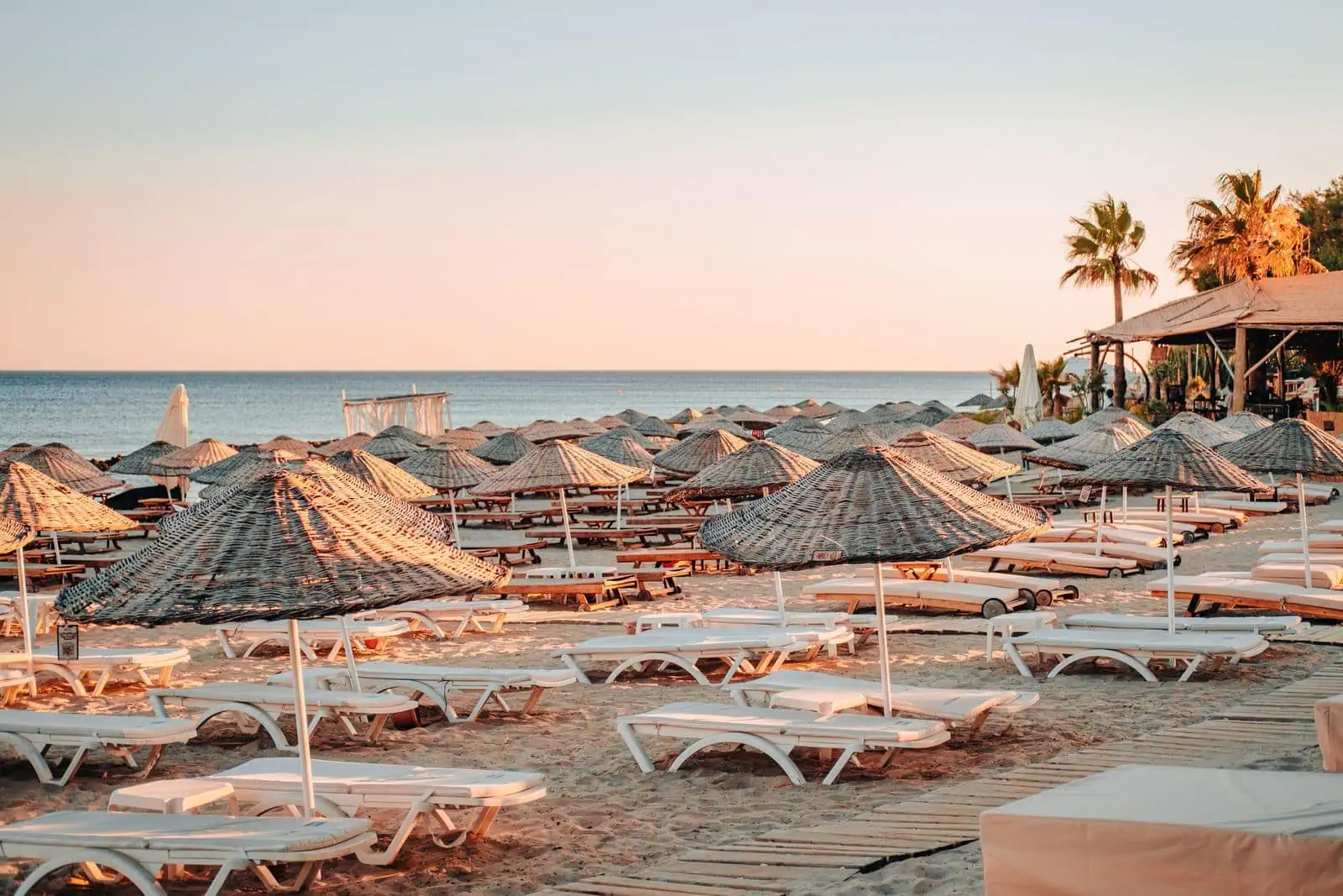 Cuándo viajar a Turquía: clima mes a mes por regiones en 2026 3 Playa de la riviera turca con hamacas y palmeras