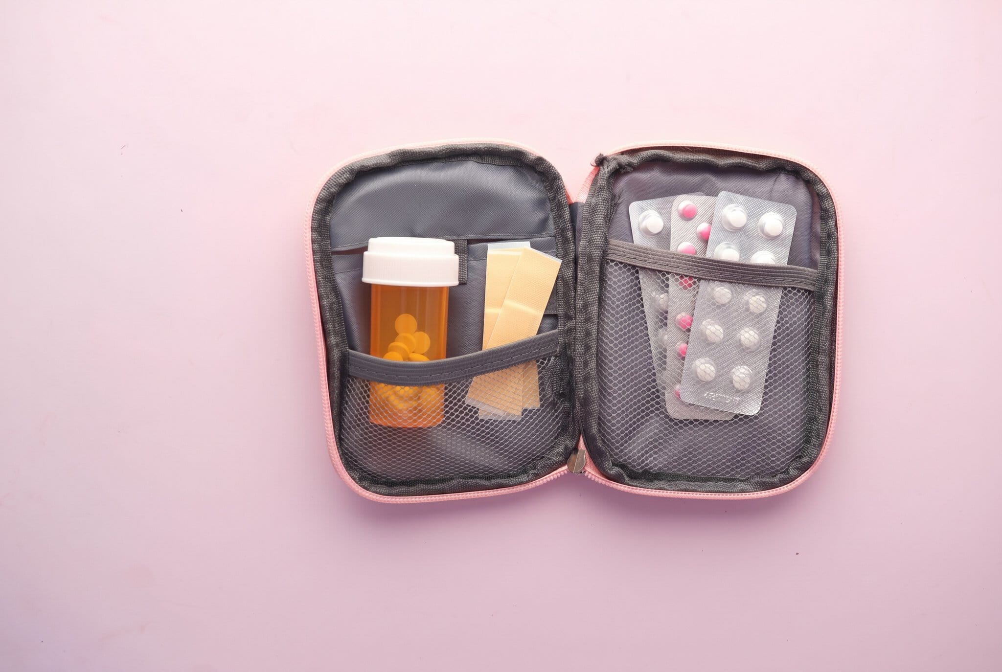 Trusă medicală de călătorie: ce să pui în ea (listă completă) pentru 2026 1 Trusă medicală de călătorie deschisă cu medicamente și plasturi
